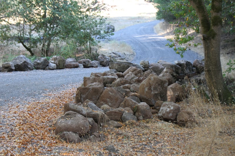Engineered rock retaining wall along a road built by VC Earthmoving in Sonoma County